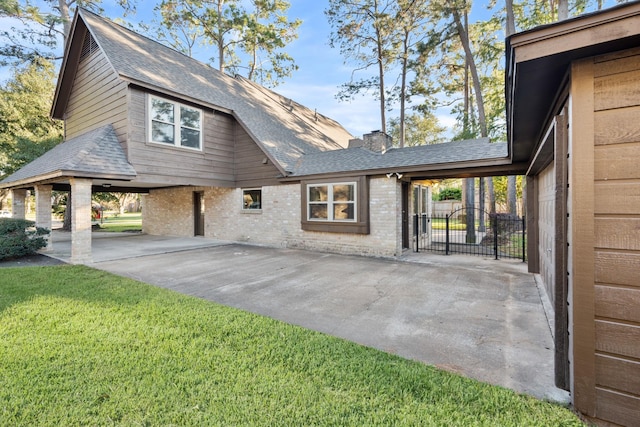 view of home's exterior featuring brick siding, a yard, roof with shingles, a gate, and a chimney