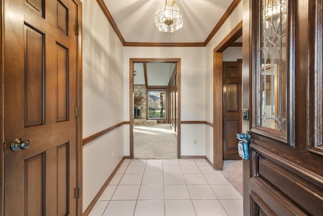 foyer with light carpet, light tile patterned floors, baseboards, and crown molding