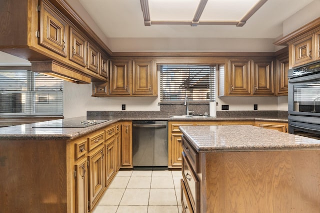 kitchen with dark stone counters, stainless steel appliances, a sink, and light tile patterned flooring