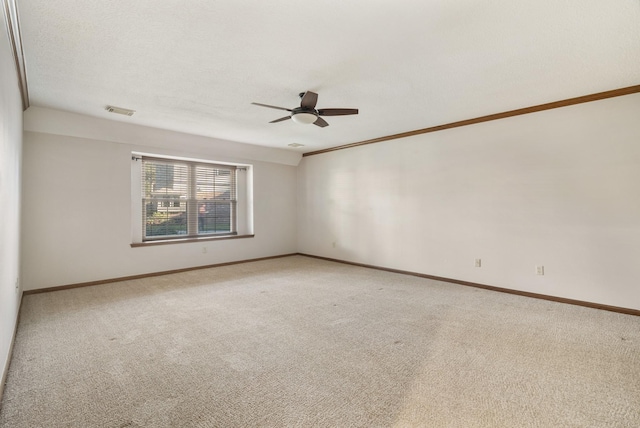 empty room featuring baseboards, visible vents, and light colored carpet