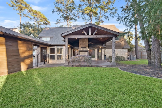 back of property with a patio area, a shingled roof, fence, and a yard