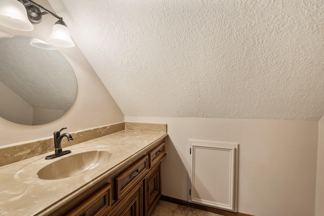 bathroom featuring lofted ceiling, a textured ceiling, and vanity