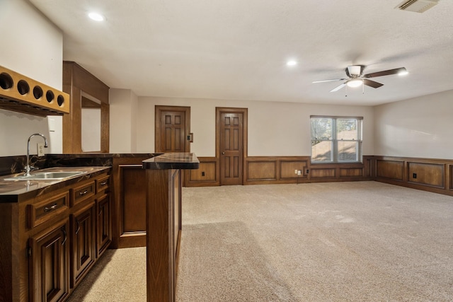 bar with visible vents, light colored carpet, a sink, and wainscoting