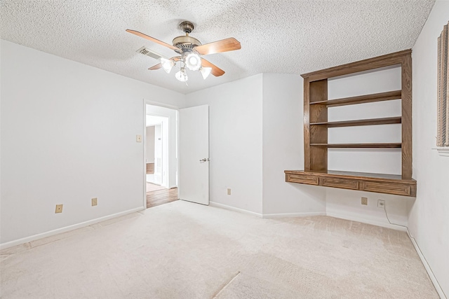 interior space with visible vents, baseboards, a textured ceiling, and a ceiling fan