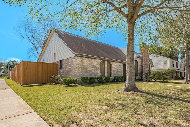 view of front of property with brick siding, a front lawn, and roof with shingles