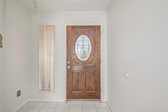 entryway featuring a textured ceiling and baseboards