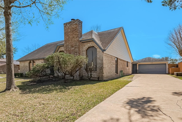 view of front facade with a chimney, concrete driveway, a front lawn, a garage, and brick siding