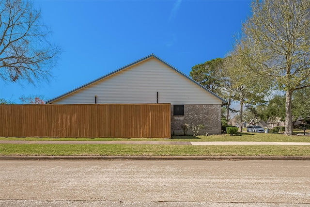 view of home's exterior featuring brick siding and a lawn