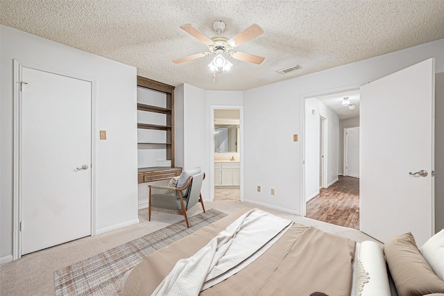 bedroom featuring a textured ceiling, baseboards, visible vents, ceiling fan, and light carpet