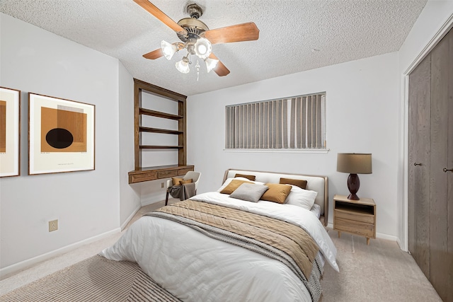 bedroom with a closet, carpet flooring, a textured ceiling, and baseboards