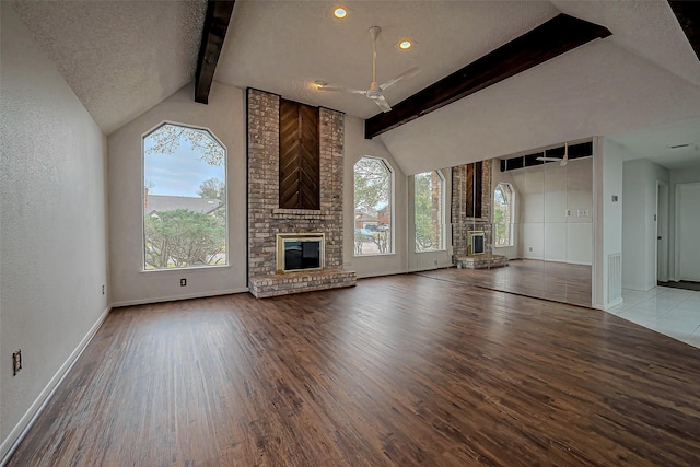 unfurnished living room featuring wood finished floors, plenty of natural light, and a fireplace