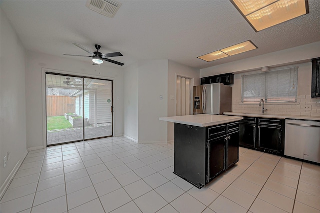 kitchen with dark cabinetry, visible vents, a sink, stainless steel appliances, and light countertops