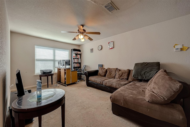 living room with a textured ceiling, ceiling fan, visible vents, and light colored carpet