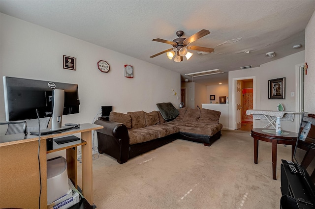 living room featuring visible vents, attic access, a ceiling fan, light carpet, and a textured ceiling