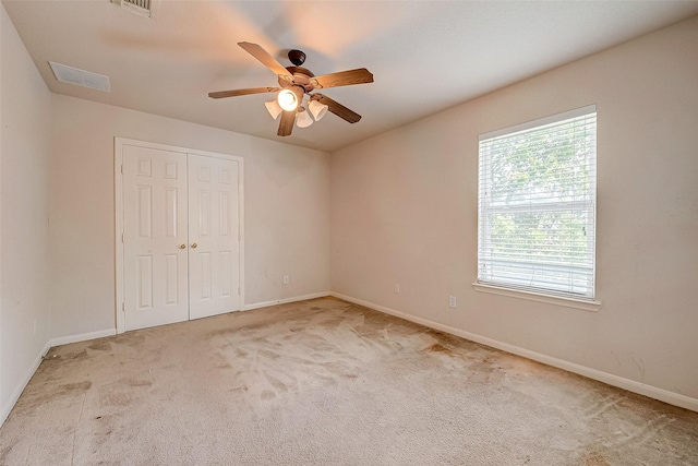 unfurnished bedroom with carpet floors, a closet, visible vents, and baseboards