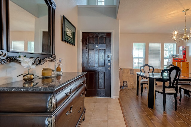 foyer entrance with a notable chandelier and light wood-style flooring