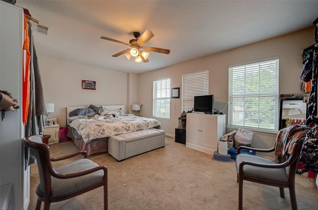 carpeted bedroom with ceiling fan and visible vents