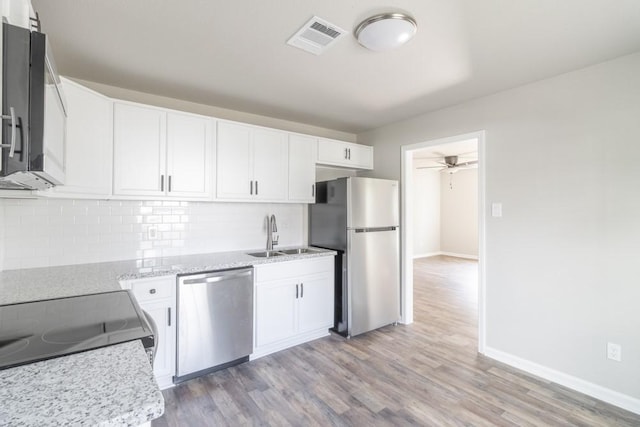 kitchen featuring backsplash, visible vents, stainless steel appliances, and a sink