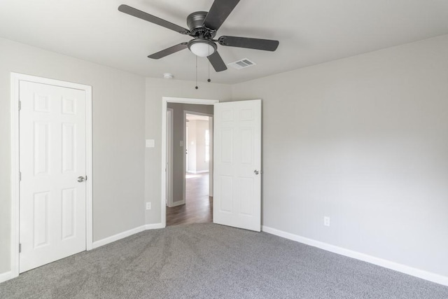 unfurnished bedroom with a ceiling fan, carpet, visible vents, and baseboards