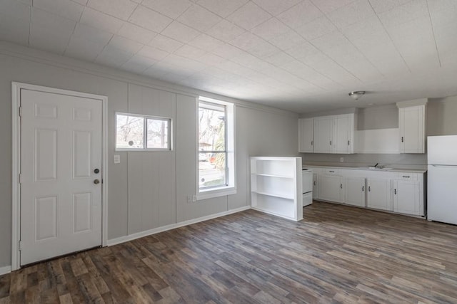 entrance foyer with crown molding, dark wood finished floors, and baseboards