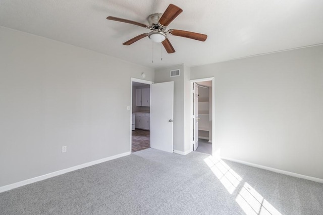 unfurnished bedroom featuring carpet floors, baseboards, visible vents, and a ceiling fan