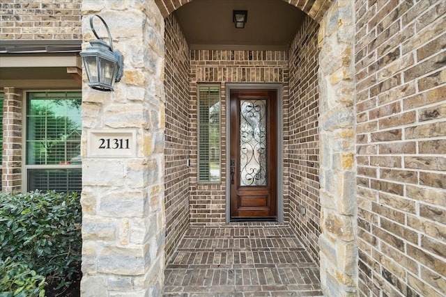 entrance to property featuring brick siding