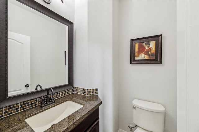 bathroom with tasteful backsplash, vanity, and toilet