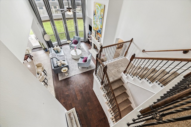 living area featuring stairs, ceiling fan, and wood finished floors