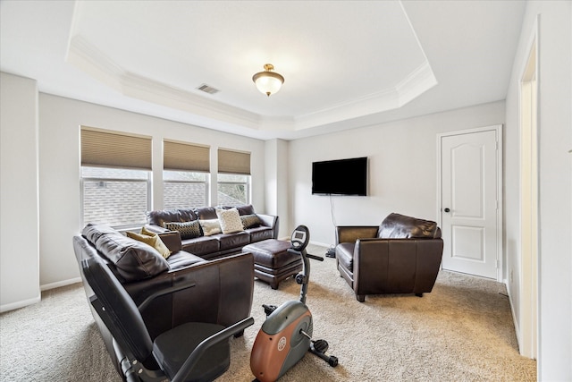 carpeted living area featuring baseboards, visible vents, a raised ceiling, and crown molding