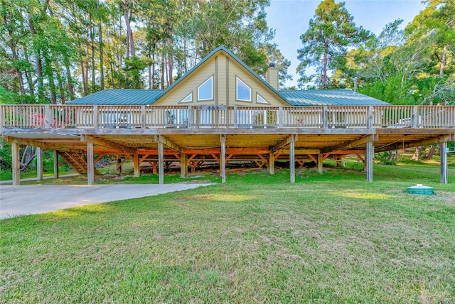 back of property with metal roof, a yard, a chimney, and a wooden deck