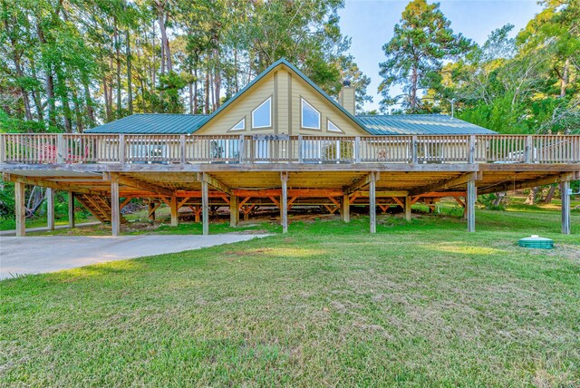 480 Caney Creek Dr, Livingston, TX 77351 - view of front of house with a wooden deck, metal roof, a front yard, and a chimney
