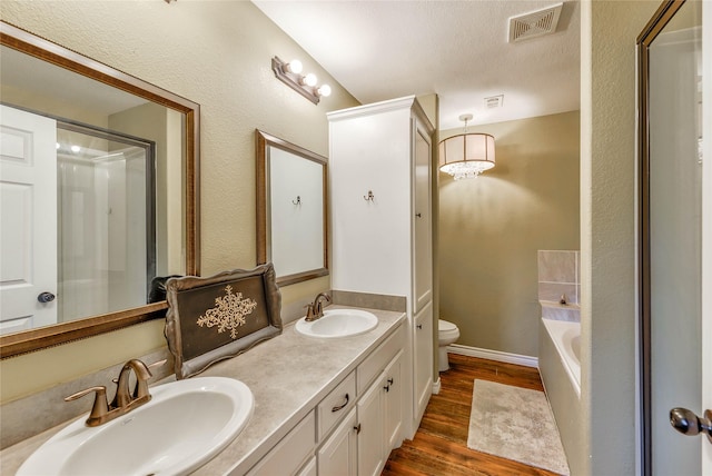 full bath featuring toilet, visible vents, a sink, and wood finished floors