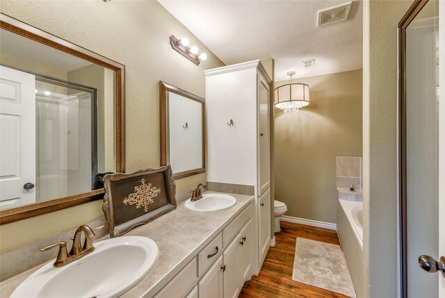 480 Caney Creek Dr, Livingston, TX 77351 - full bath featuring wood finished floors, toilet, a garden tub, and double vanity