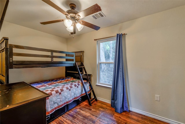 bedroom featuring a ceiling fan, wood finished floors, visible vents, and baseboards