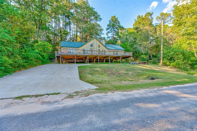 480 Caney Creek Dr, Livingston, TX 77351 - view of front of house featuring a wooden deck, metal roof, a front yard, a chimney, and driveway