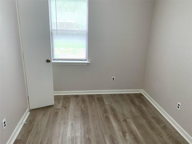 spare room featuring wood finished floors and baseboards