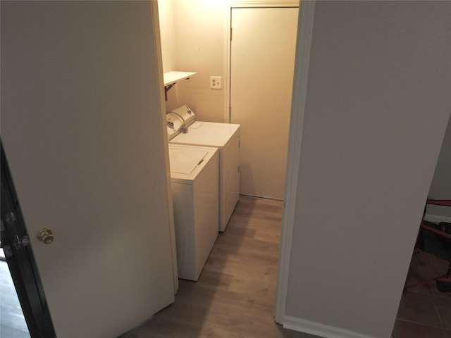 clothes washing area featuring laundry area, light wood-type flooring, and washer and dryer