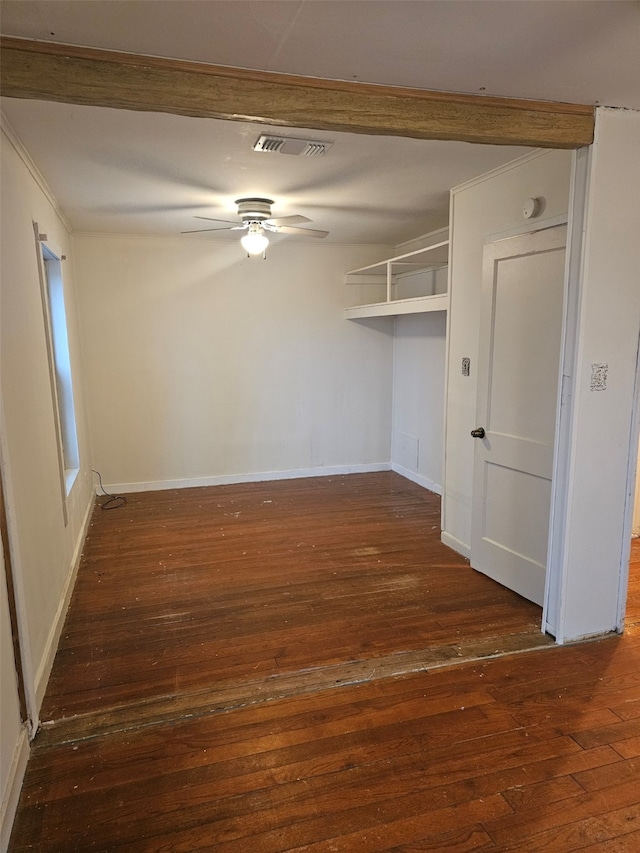 unfurnished room featuring ceiling fan, visible vents, dark wood finished floors, and baseboards