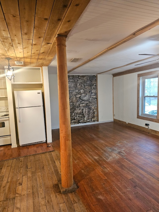 below grade area featuring freestanding refrigerator, wood ceiling, visible vents, and hardwood / wood-style flooring