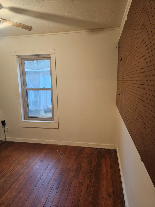 unfurnished room featuring a ceiling fan, dark wood finished floors, a textured ceiling, and baseboards