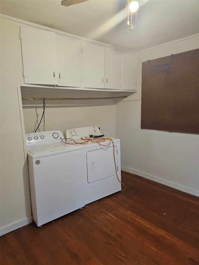 laundry room featuring cabinet space, baseboards, dark wood-style flooring, and washer and dryer