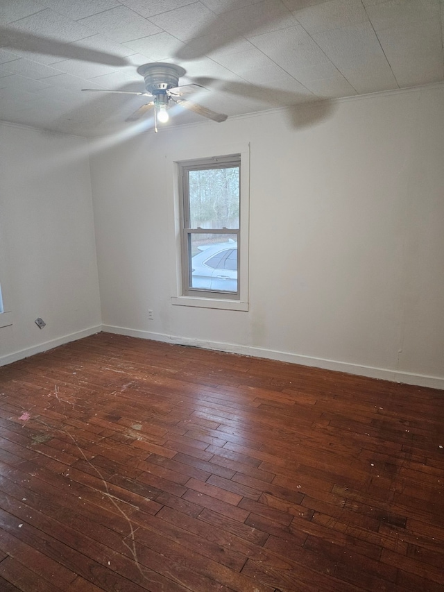 unfurnished room with dark wood-style floors, baseboards, and a ceiling fan