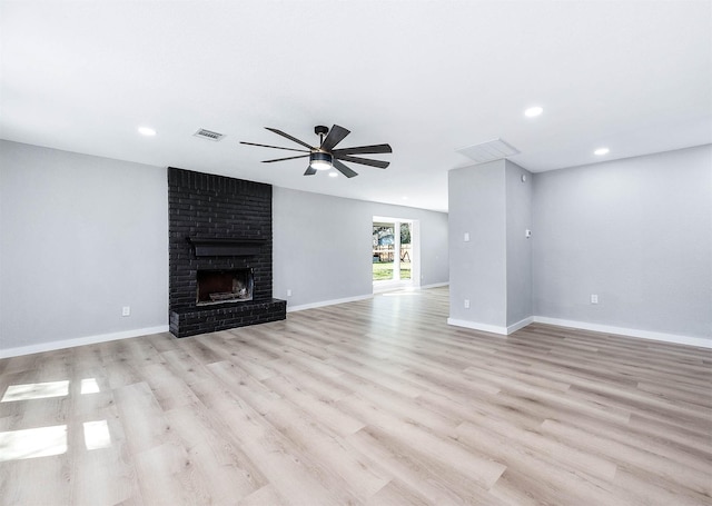 unfurnished living room featuring a ceiling fan, a fireplace, light wood-style flooring, and baseboards