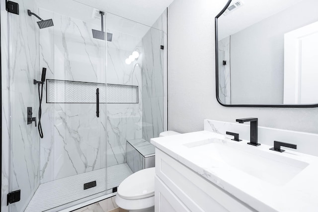 full bath with toilet, a marble finish shower, visible vents, and vanity