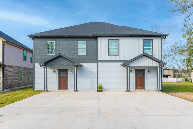 view of front facade with board and batten siding, concrete driveway, and a shingled roof