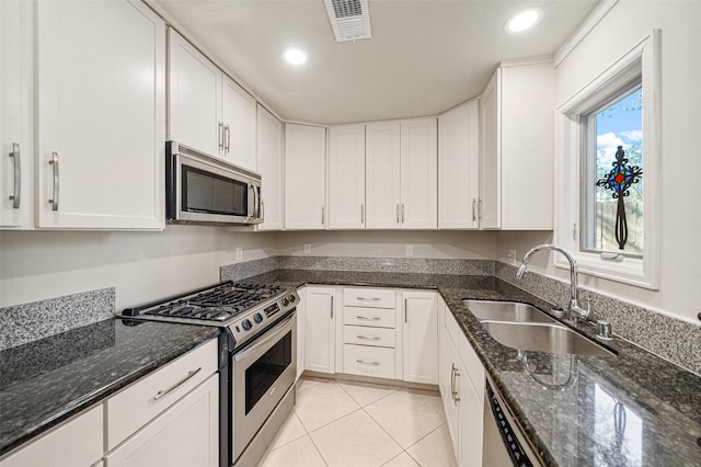 kitchen featuring appliances with stainless steel finishes, a sink, visible vents, and white cabinetry