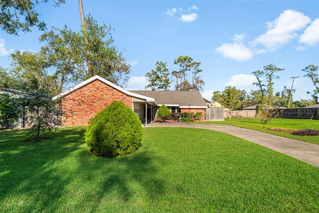 single story home with brick siding, fence, and a front lawn