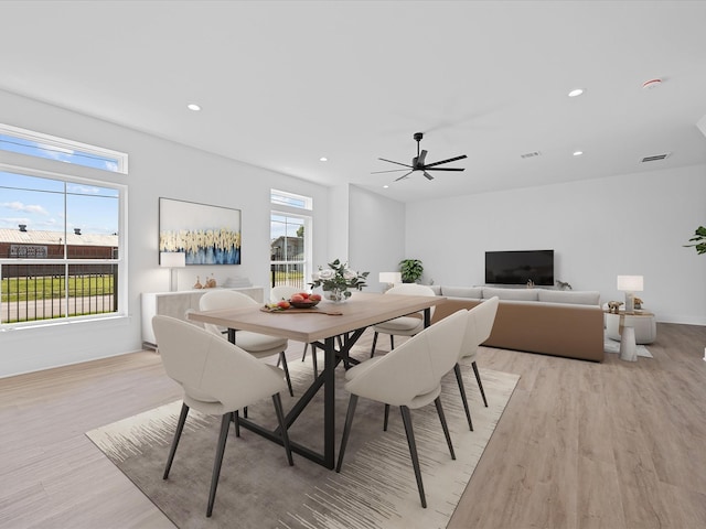 dining room featuring light wood finished floors, visible vents, and a wealth of natural light