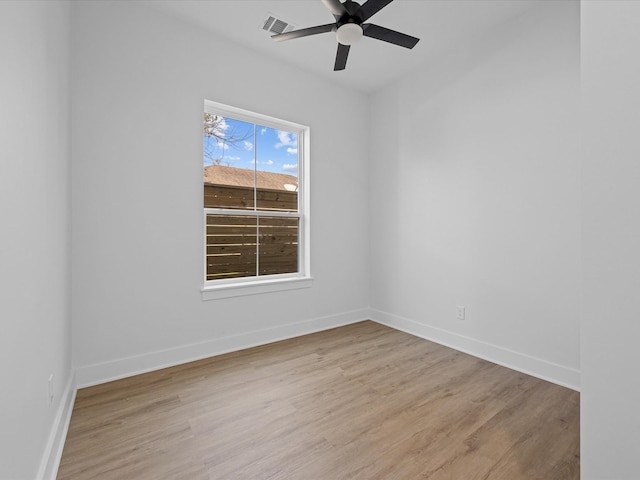 unfurnished room with baseboards, a ceiling fan, visible vents, and light wood-style floors