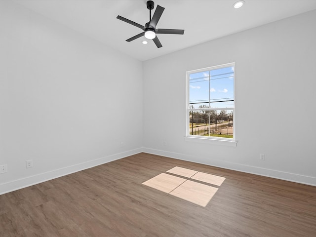 spare room featuring recessed lighting, baseboards, and wood finished floors